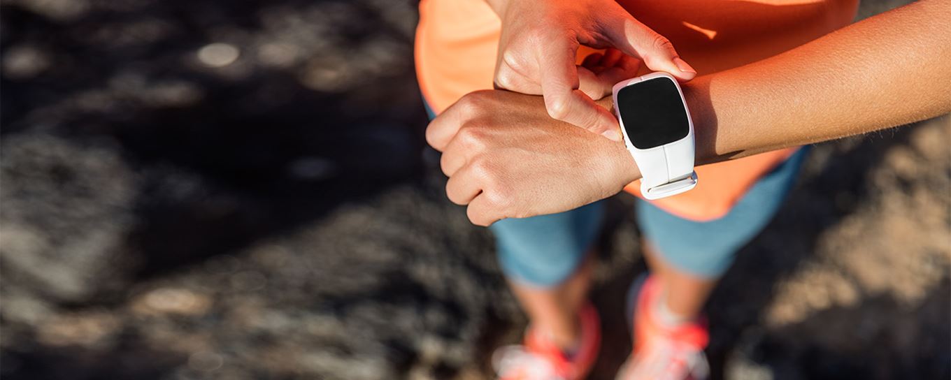 Vrouw kijkt op haar smartwatch tijdens het hardlopen