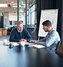 twee mannen aan tafel in overleg