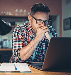Man in concentratie achter de laptop