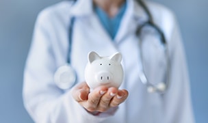 Een dokter met een doktersjas die een spaarvarkentje vasthoudt