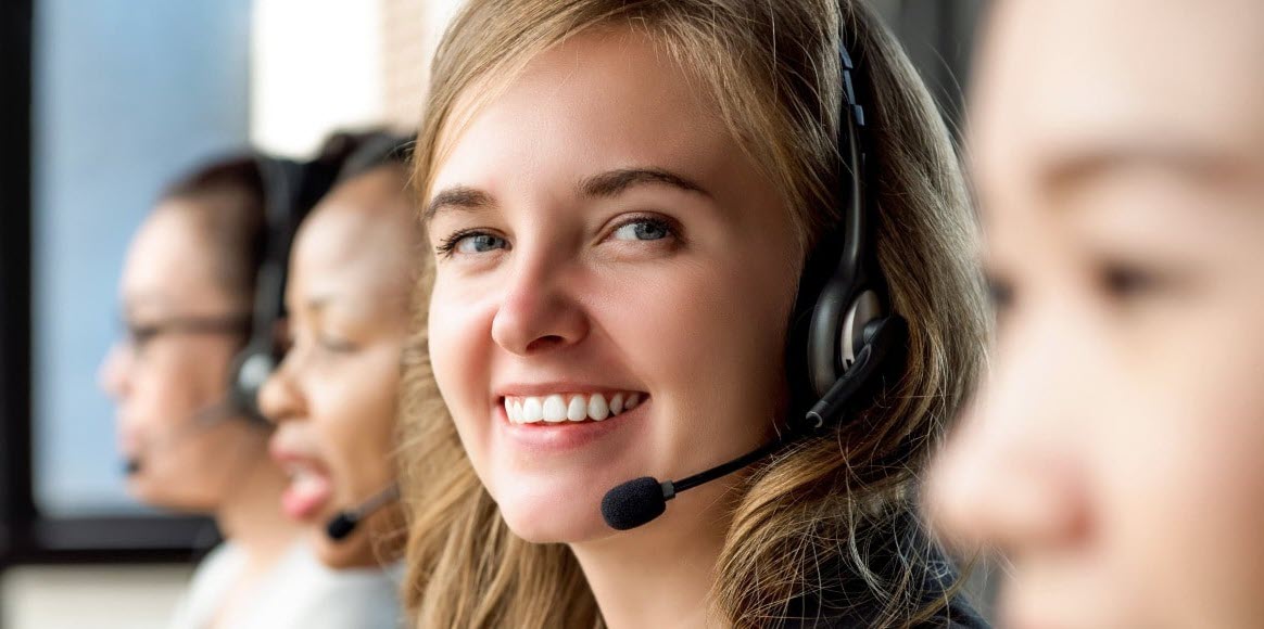 Klantenservice medewerker lacht vriendelijk en kijkt in de camera