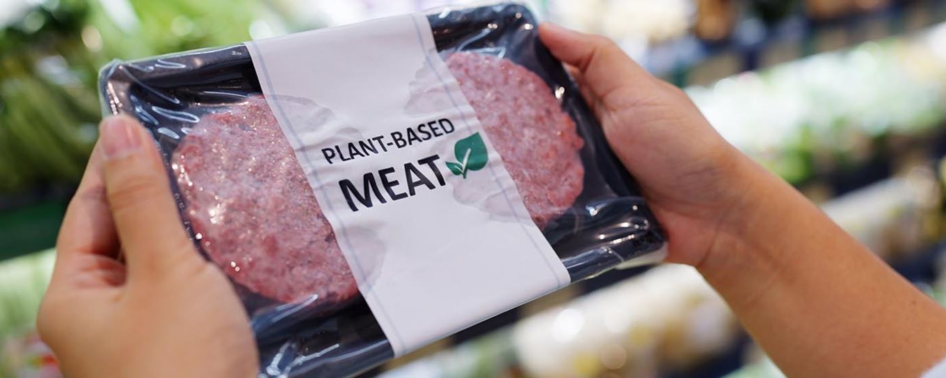 Twee handen die een verpakking met plant-based meat vasthouden | vleesvervangers | a.s.r. | Week zonder Vlees