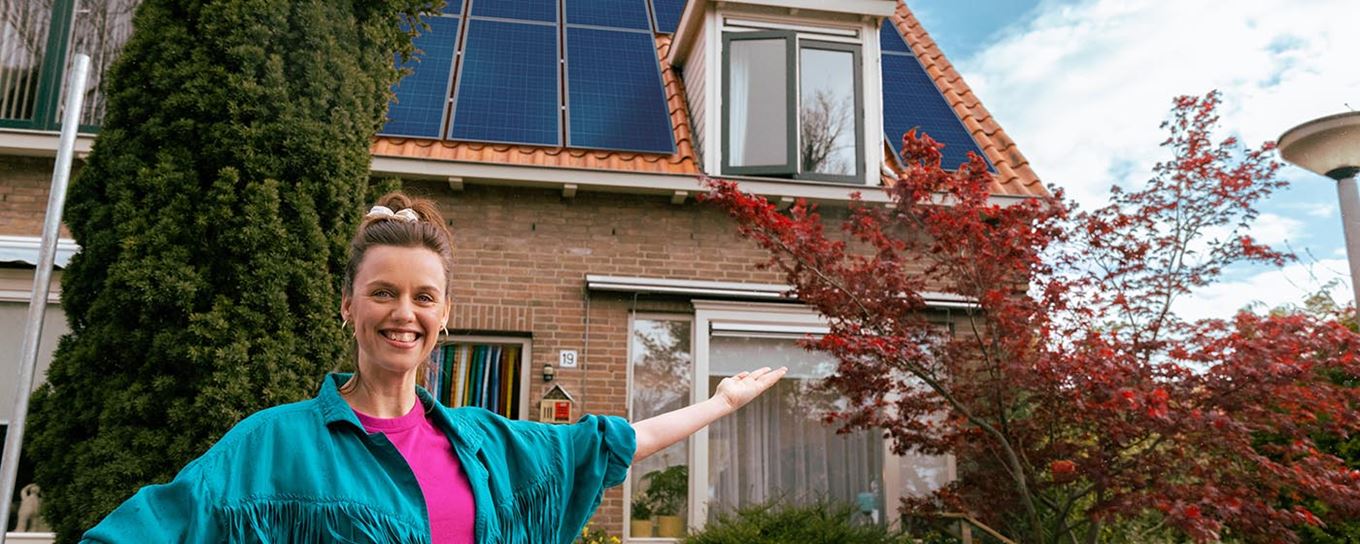 Vrouw voor huis met zonnepanelen | a.s.r.