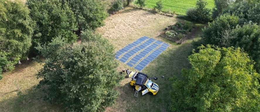 elektrische auto die opgeladen wordt in een veld met eigen zonnepanelen