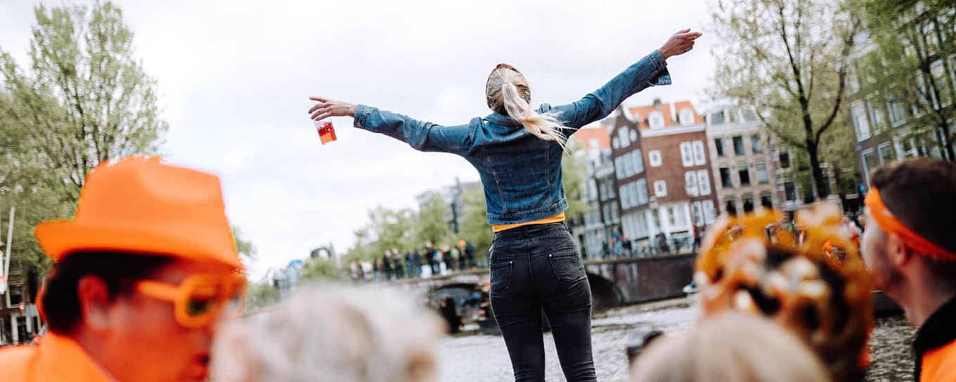 Jonge vrouw tijdens Koningsdag in Amsterdam genietend van het leven | a.s.r. | geef zakkenrollers geen kans