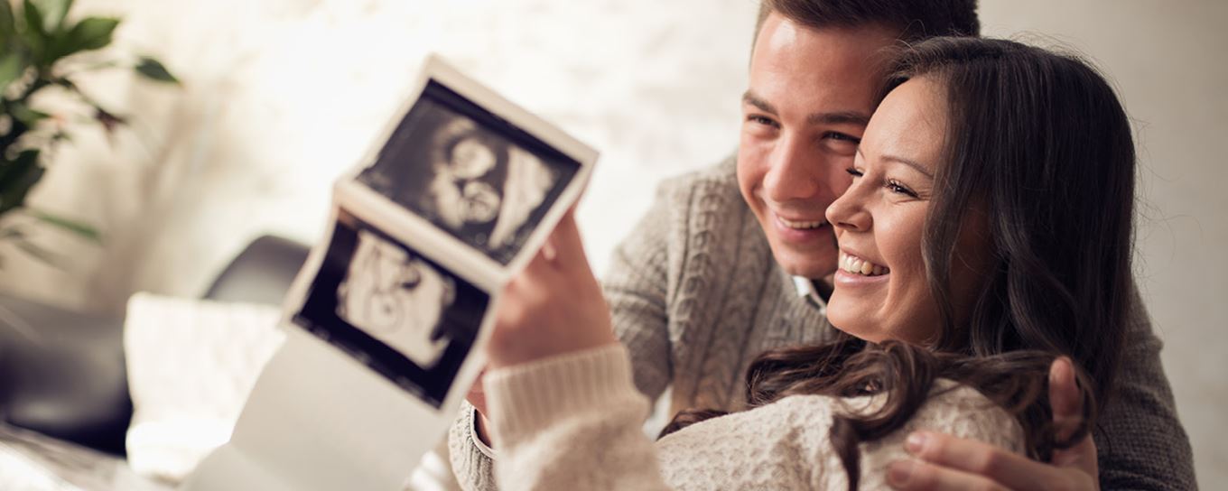 Man en vrouw kijken blij naar de echo van hun kind | a.s.r. | zwanger