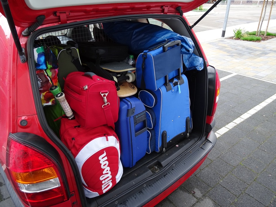 Open achterbak van een auto die volgepakt is met tassen en koffers