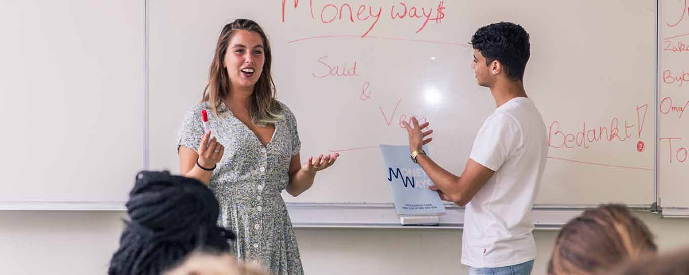 Twee peer educators voor de klas tijdens een les van MoneyWays - a.s.r.