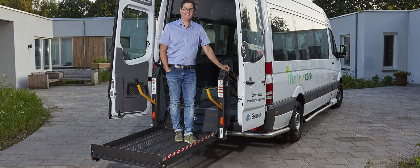 Jan Peter van de Glind bij nieuwe rolstoelbus voor de dagbesteding van zijn dochter