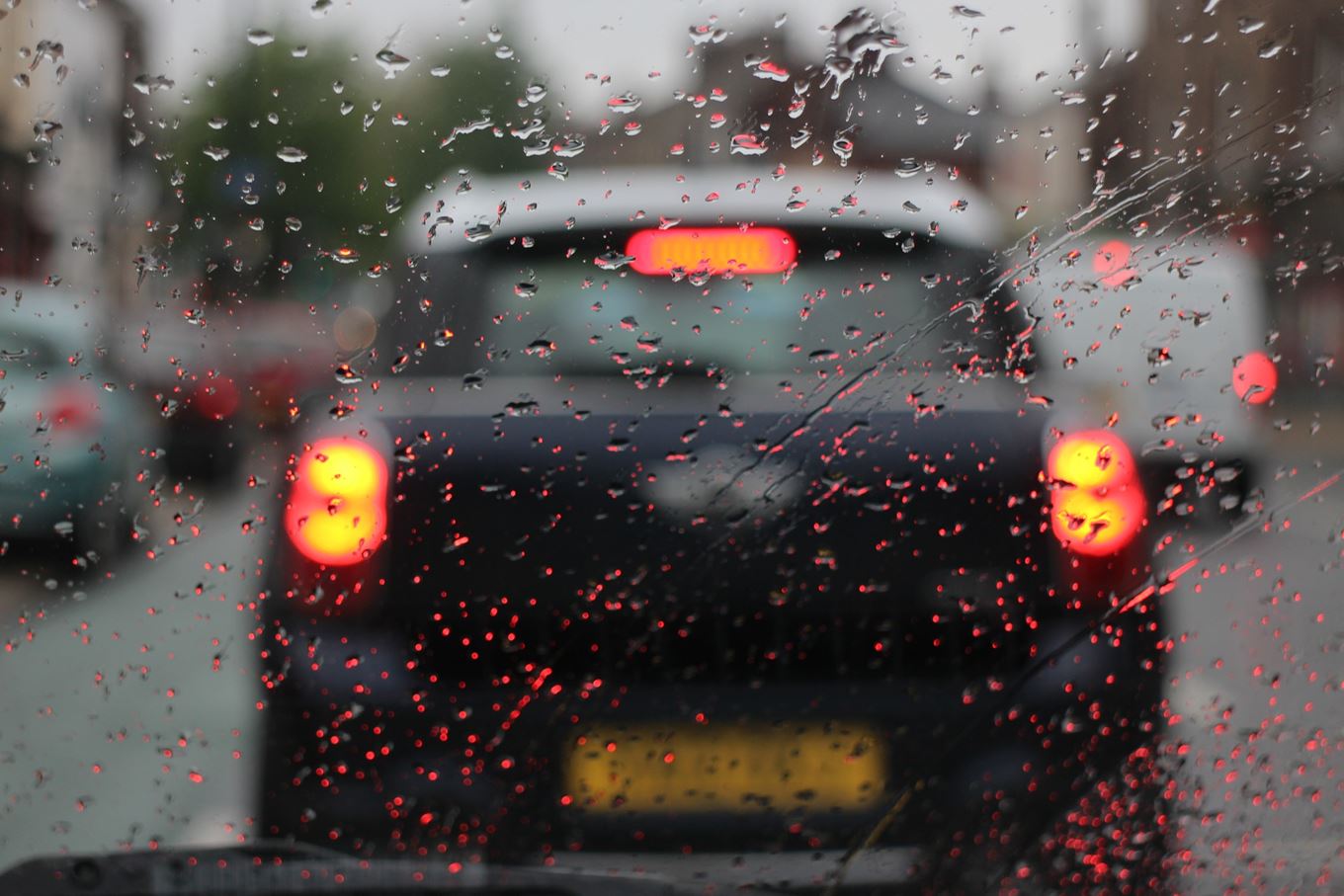 auto met remlichten in de regen