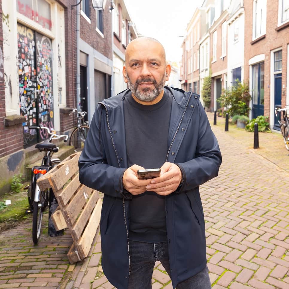 Man met telefoon op straat | a.s.r. | Ik Denk Vooruit