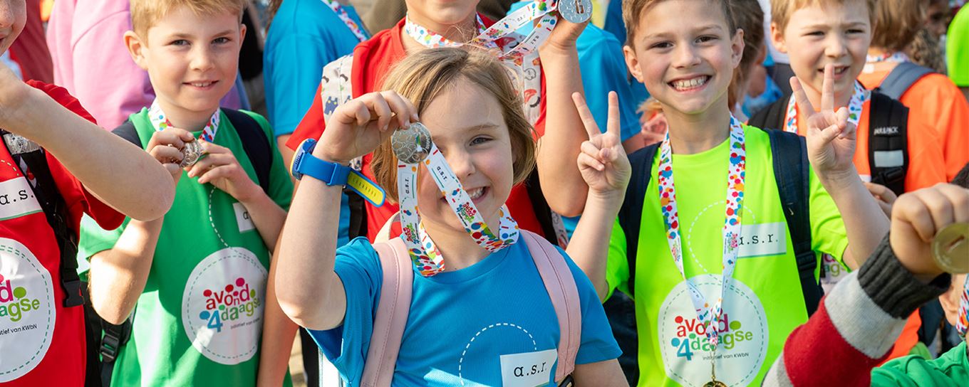Kinderen lachend op de foto met hun medaille van de avond4daagse