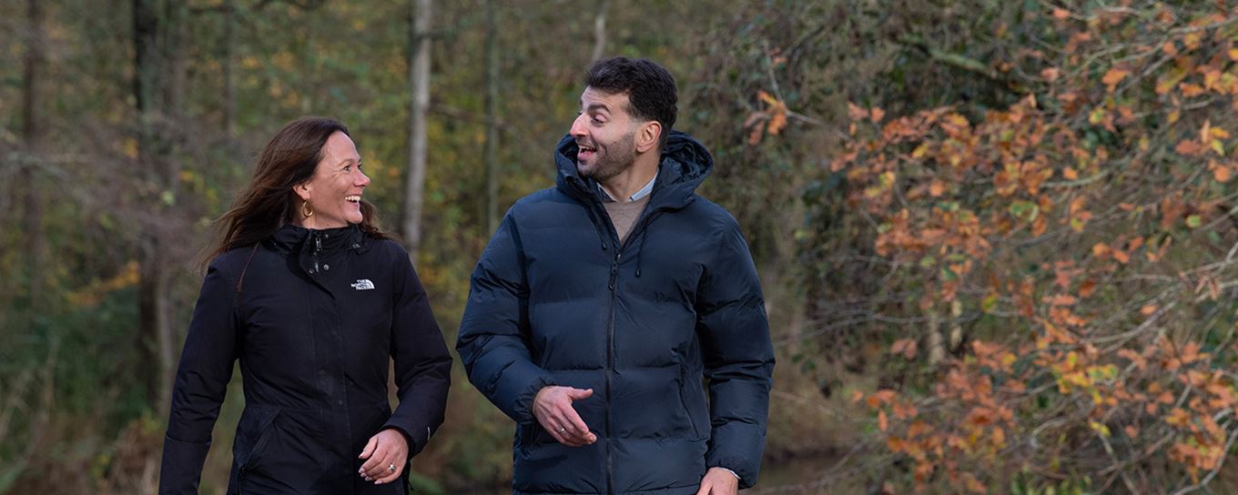 Jonge man en jonge vrouw samen wandelend in het park. ze lachen naar elkaar