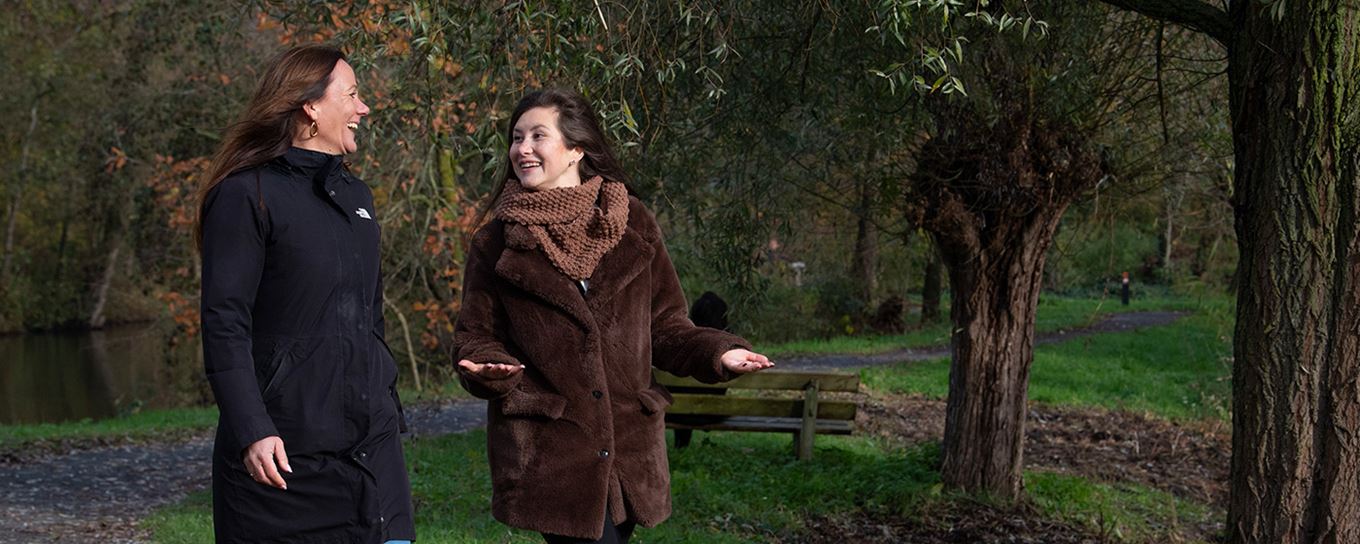 2 vrouwen gezellig aan de wandel in het park