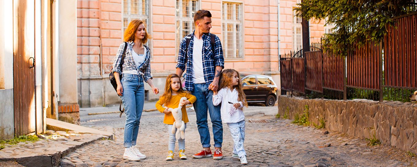 Man, vrouw en hun 2 kleine kinderen aan de wandel in een stad