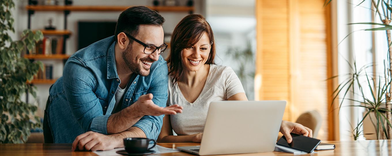 Man en vrouw kijkend naar de laptop voor ze en samen wat bespreken