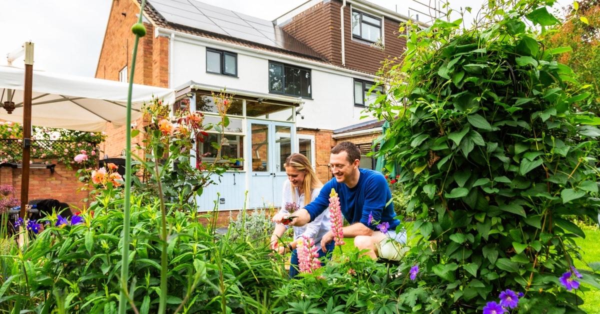 Afbeelding van een man en vrouw die in de tuin aan het snoeien zijn