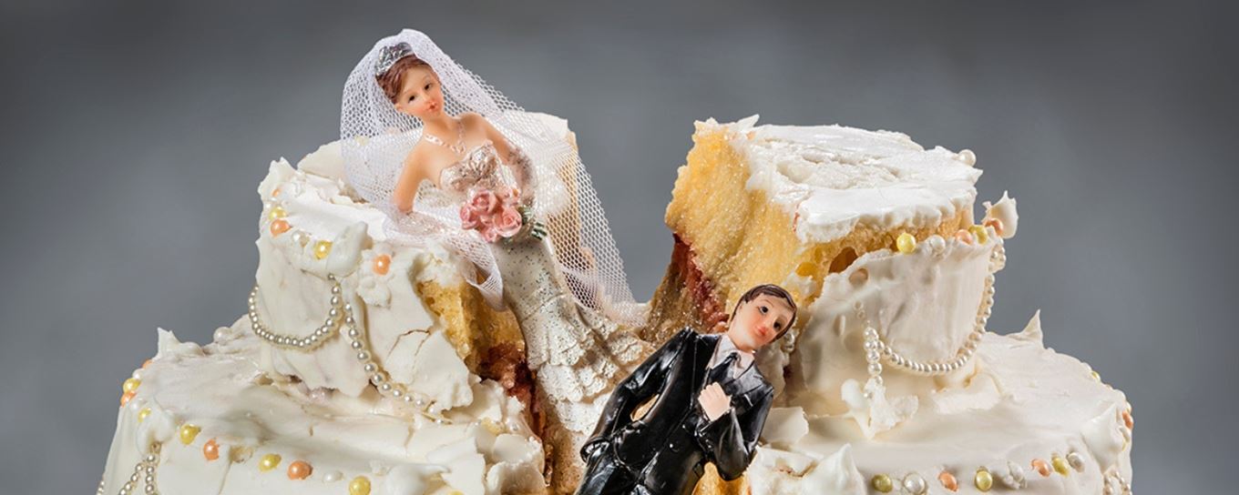 Afbeelding van een gebroken taart met een bruid en bruidegom poppetje