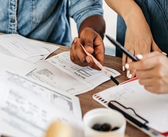 Twee personen aan tafel met papierwerk
