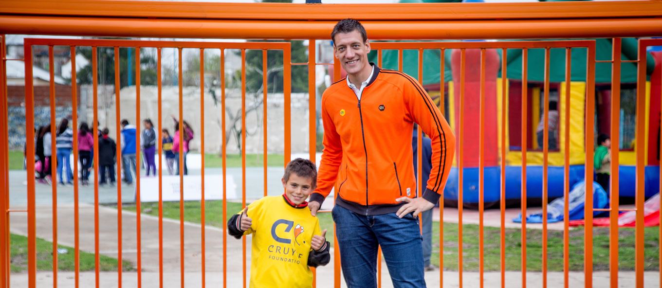 Niels Meijer samen met een kind voor een oranje goal van een Cruyff Court